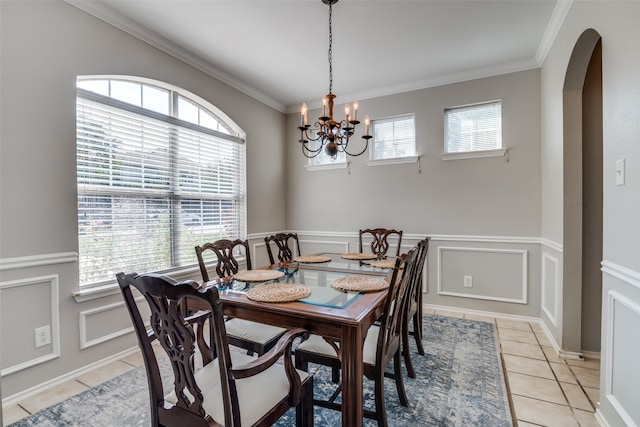 tiled dining space with an inviting chandelier and ornamental molding