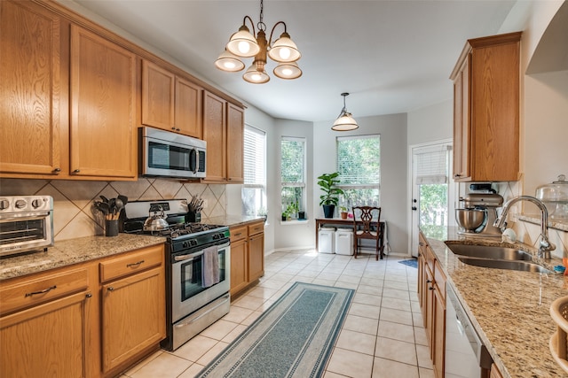 kitchen featuring light tile patterned flooring, pendant lighting, sink, stainless steel appliances, and backsplash