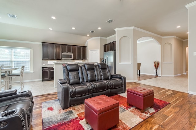 living room with light wood-type flooring and crown molding