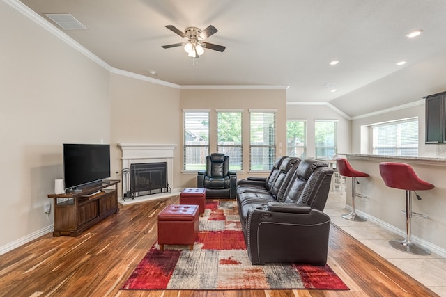 living room with ceiling fan, hardwood / wood-style flooring, crown molding, and lofted ceiling