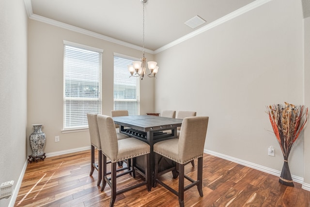 dining space featuring an inviting chandelier, ornamental molding, and hardwood / wood-style flooring