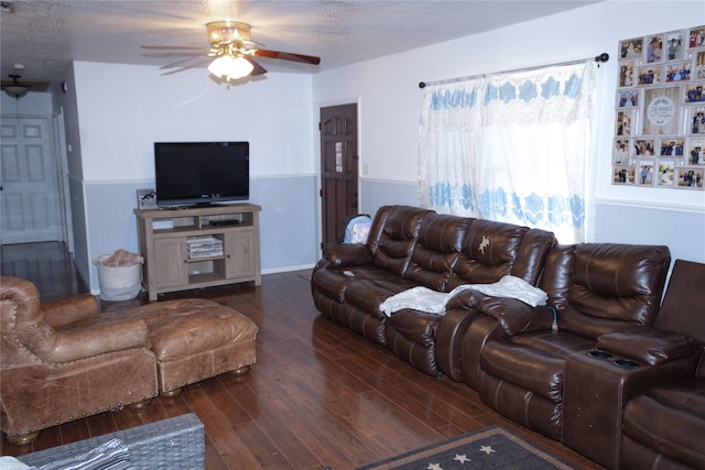 living room with a textured ceiling, dark hardwood / wood-style floors, and ceiling fan