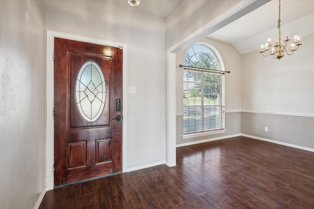 foyer entrance with a notable chandelier, lofted ceiling, and dark hardwood / wood-style flooring