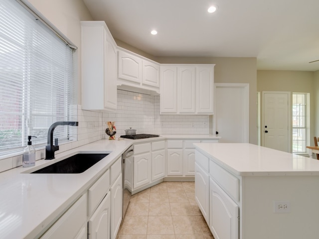 kitchen featuring a kitchen island, white cabinetry, sink, and appliances with stainless steel finishes