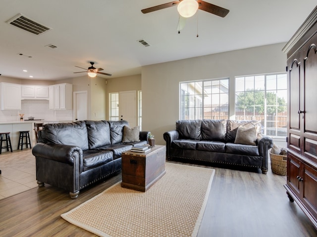 living room featuring wood-type flooring and ceiling fan