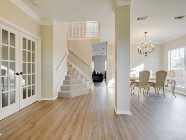 dining room with french doors, a notable chandelier, crown molding, and hardwood / wood-style floors