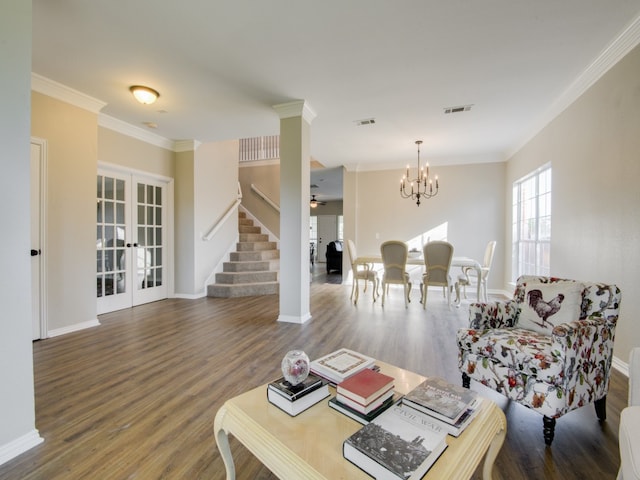 living room featuring ornamental molding, wood-type flooring, an inviting chandelier, and french doors