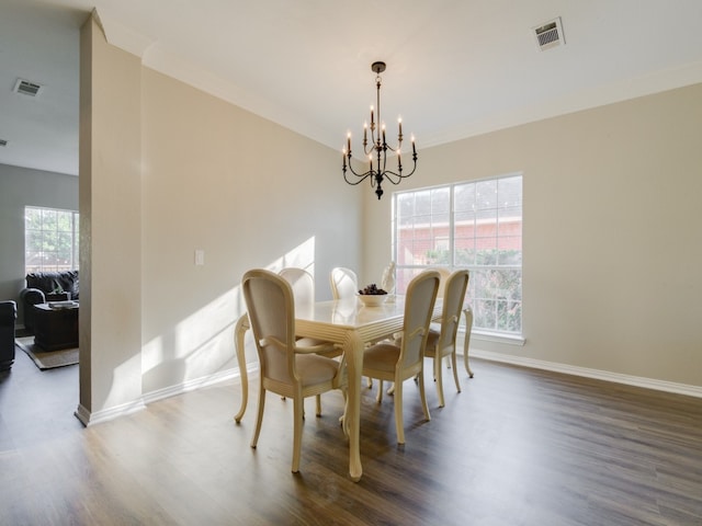 dining area featuring crown molding, hardwood / wood-style floors, and a notable chandelier