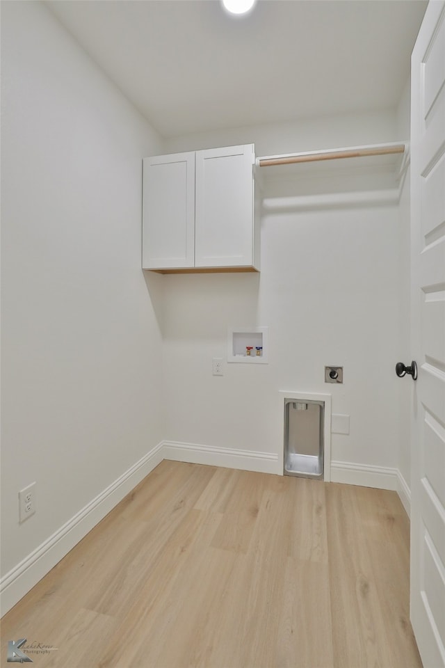 clothes washing area with washer hookup, cabinets, light hardwood / wood-style flooring, and hookup for an electric dryer