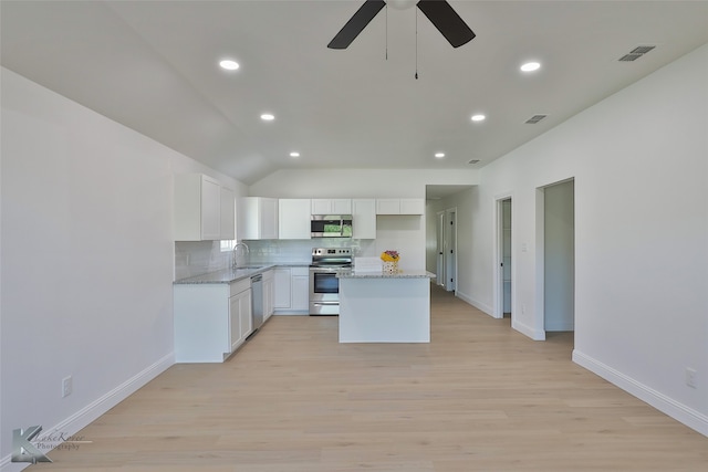 kitchen featuring sink, a kitchen island, stainless steel appliances, white cabinets, and light hardwood / wood-style flooring