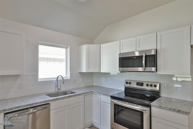 kitchen featuring white cabinetry, stainless steel appliances, and vaulted ceiling