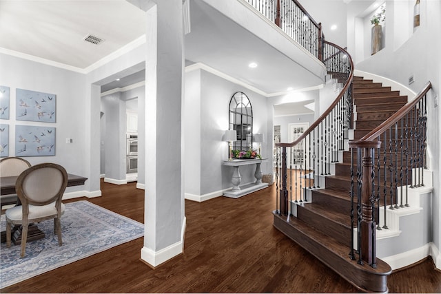 foyer entrance featuring dark wood-type flooring and ornamental molding