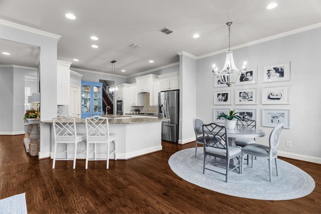 kitchen with stainless steel appliances, white cabinetry, pendant lighting, and kitchen peninsula