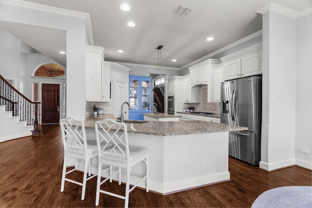 kitchen featuring appliances with stainless steel finishes, dark hardwood / wood-style floors, white cabinetry, backsplash, and kitchen peninsula