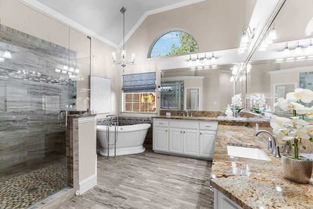 bathroom with an inviting chandelier, high vaulted ceiling, vanity, ornamental molding, and separate shower and tub