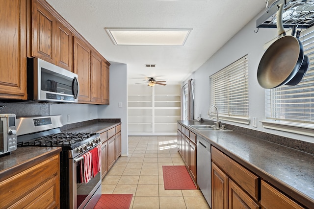 kitchen featuring ceiling fan, light tile patterned floors, stainless steel appliances, and sink