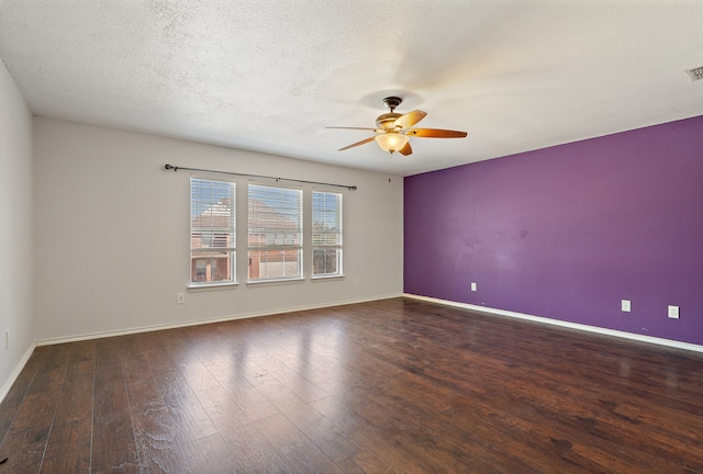 empty room with ceiling fan, a textured ceiling, and dark wood-type flooring