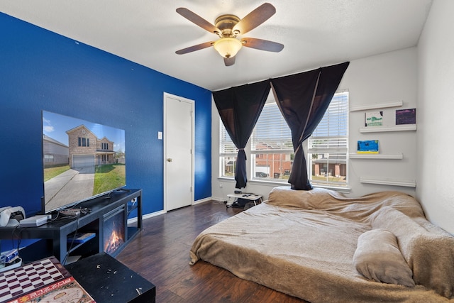 bedroom featuring a textured ceiling, ceiling fan, and dark wood-type flooring