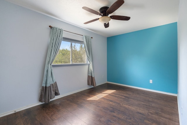 spare room featuring ceiling fan and dark wood-type flooring