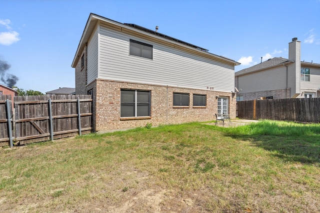 rear view of property with a yard