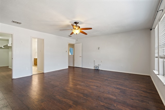 unfurnished room with ceiling fan, dark wood-type flooring, and a textured ceiling