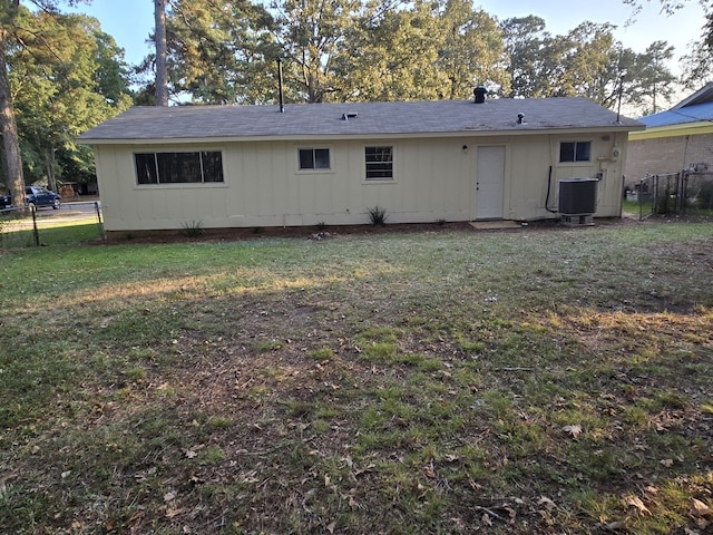 rear view of property with a lawn and central air condition unit