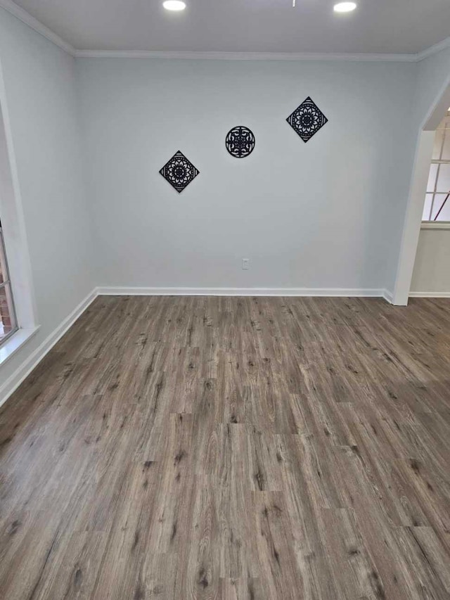 empty room with ornamental molding and wood-type flooring