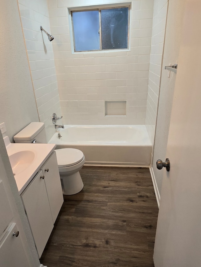 full bathroom with wood-type flooring, vanity, tiled shower / bath combo, and toilet