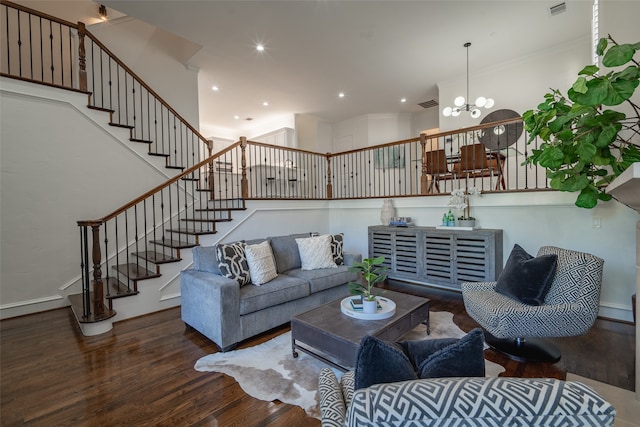 living room with wood-type flooring, crown molding, and an inviting chandelier