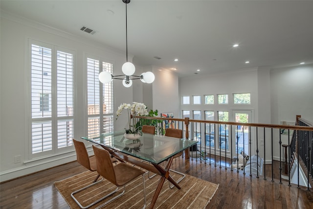 dining room featuring crown molding, a chandelier, and dark hardwood / wood-style flooring