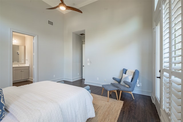 bedroom with ceiling fan, ensuite bathroom, dark hardwood / wood-style floors, and a high ceiling