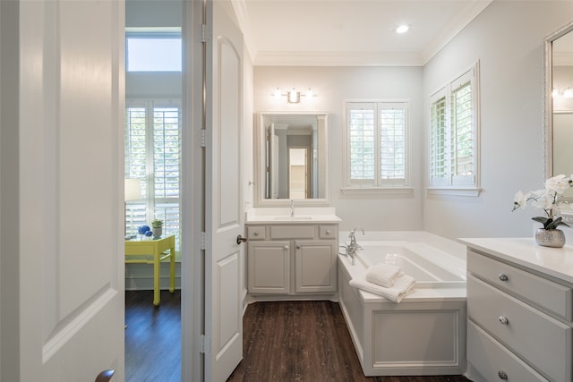 bathroom featuring wood-type flooring, vanity, a bathing tub, and ornamental molding