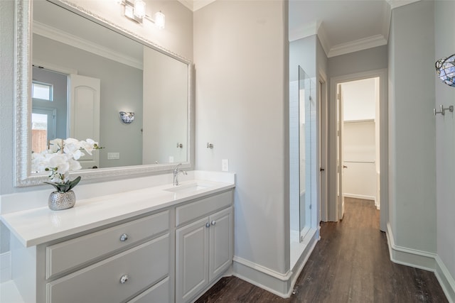 bathroom featuring walk in shower, ornamental molding, hardwood / wood-style floors, and vanity