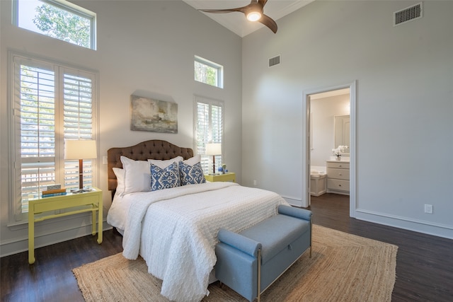 bedroom featuring multiple windows, ceiling fan, a towering ceiling, and dark hardwood / wood-style flooring