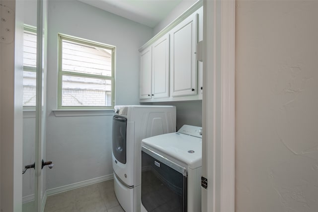 laundry room with independent washer and dryer, light tile patterned flooring, and cabinets