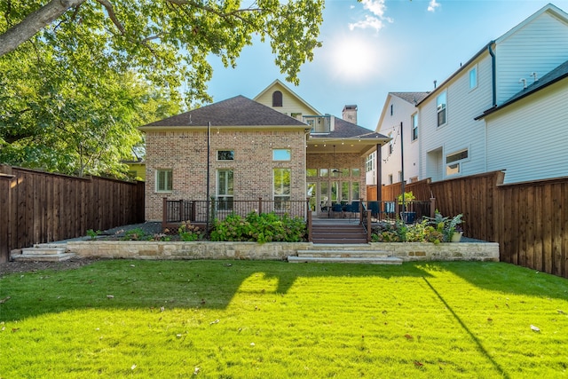 rear view of property with a yard and a wooden deck