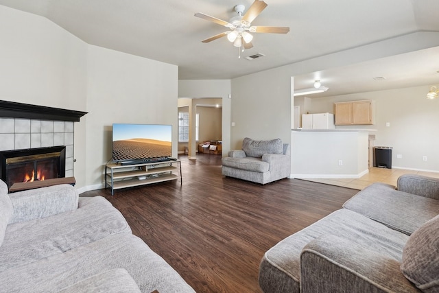 living room featuring a fireplace, hardwood / wood-style floors, vaulted ceiling, and ceiling fan