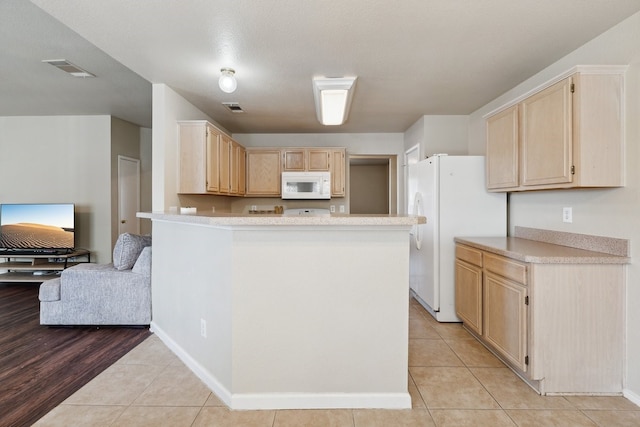 kitchen with white appliances, light hardwood / wood-style floors, light brown cabinets, and kitchen peninsula