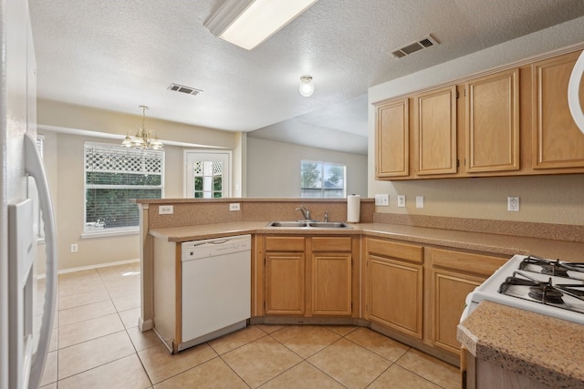 kitchen featuring pendant lighting, white appliances, sink, kitchen peninsula, and a textured ceiling