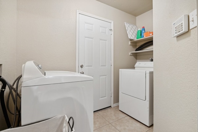 washroom with washer and dryer and light tile patterned floors