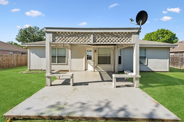 back of house with a lawn and a patio area