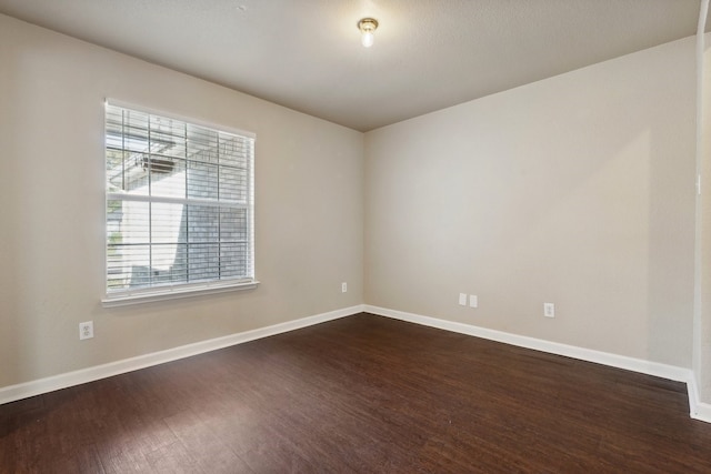 unfurnished room with dark wood-type flooring