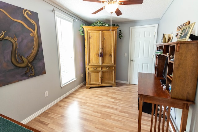 home office featuring ceiling fan, a textured ceiling, light hardwood / wood-style flooring, and ornamental molding