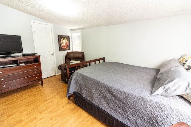 bedroom featuring a textured ceiling and light wood-type flooring