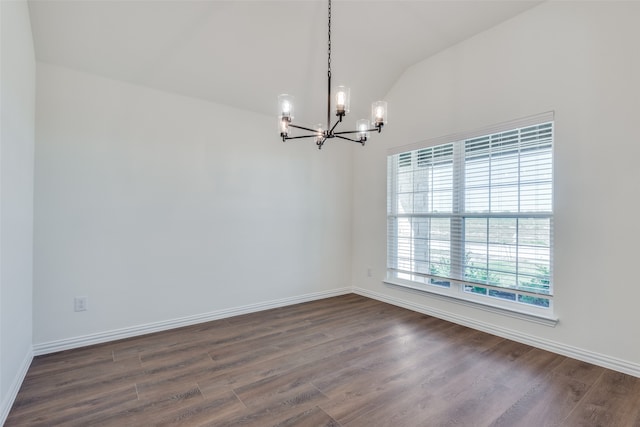 empty room with dark wood-type flooring, vaulted ceiling, and a notable chandelier