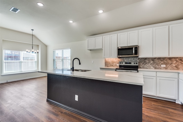 kitchen featuring stainless steel appliances, lofted ceiling, a center island with sink, and dark hardwood / wood-style flooring