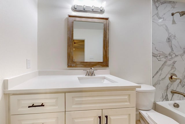 full bathroom featuring tiled shower / bath, vanity, and toilet