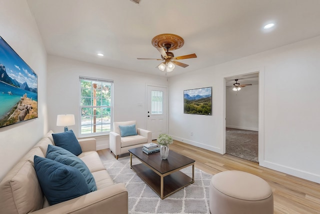 living room with light hardwood / wood-style floors and ceiling fan