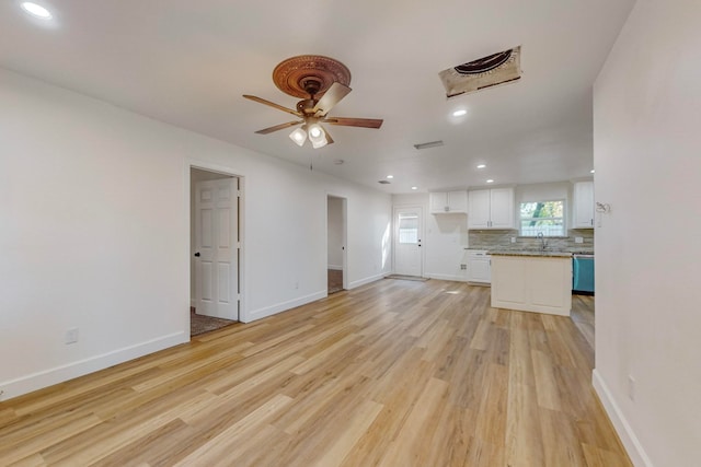 unfurnished living room with light hardwood / wood-style floors, sink, and ceiling fan