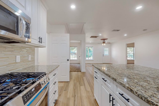 kitchen with white cabinets, stainless steel appliances, and light hardwood / wood-style floors